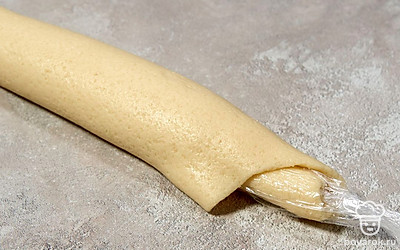 Прикройте пласт с сахаром пленкой и заверните тесто в рулет вместе с ней. После этого уберите рулет в холодильник на 3 часа.