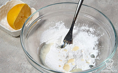 Пока выпекается печенье, выжмите сок из половины лимона. Всыпьте в него сахарную пудру, перемешайте, чтобы пудра полностью растворилась. 