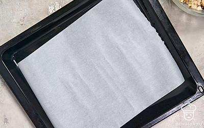 Включите духовку разогреваться до 200°C. Застелите противень листом пергаментной бумаги.