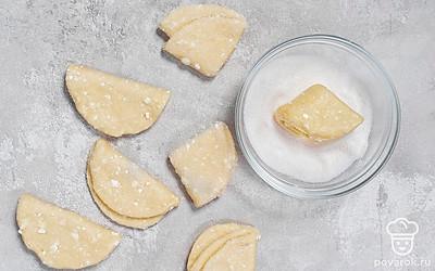 Снова обмакните одной стороной в сахар и снова сложите пополам. Немного прижмите печенье и снова обмакните в сахар. Сделайте так со всеми кружочками теста.