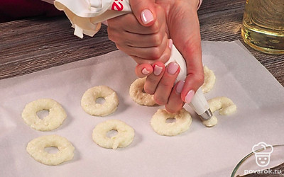 Подготовьте луковые кольца. В блендере измельчите лук в пюре. Добавьте 50 г муки, посолите и пробейте до однородной массы. Поместите луковую массу в кулинарный мешок. Выдавите на пергаментную бумагу в виде колец. На 2 часа уберите колечки в морозилку.
