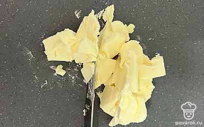 Для теста берите не все масло, а только 80 грамм. На доске масло измельчите. Если оно замороженное, работать с ним проще. 