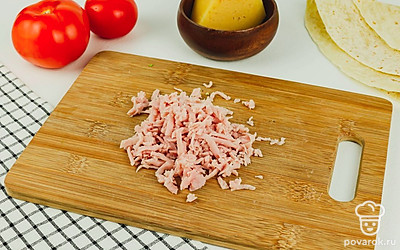 Нарежьте тонкими ломтиками колбасу.