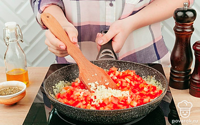 В разогретую сковороду с растительным маслом добавьте лук, чеснок и помидоры, обжаривайте все в течение 5 минут.