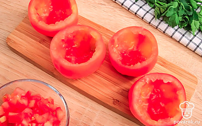 Срежьте верхушки у помидоров и ложкой выньте сердцевины. Не выбрасывайте их, они пригодятся для начинки.