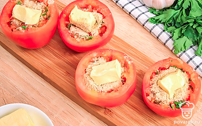 Посыпьте начинку сверху панировочными сухарями и добавьте по чайной ложке сливочного масла в каждый помидор.