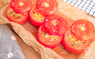 Выложите помидоры в форму для запекания, застеленную пергаментной бумагой и накройте верхушками. Отправьте помидоры запекаться в духовку на 10-15 минут.