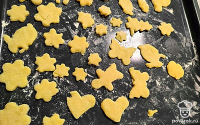 Вырежьте в помощью формочек печенье. Каждое окуните в сахар с одной стороны. Противень присыпьте мукой. Выложите печенье сахарной стороной вверх, поставьте в разогретую до 200 градусов духовку. Выпекайте около 10 минут. 
