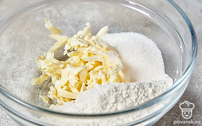 Всыпьте в миску с натертым маслом просеянную муку и половину нужного количества сахара.