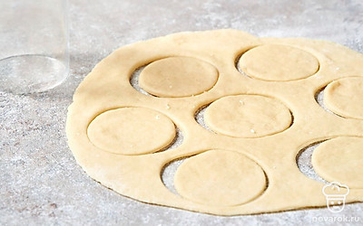 Присыпьте тесто небольшим количеством муки со стола и раскатайте его скалкой до образования пласта толщиной не более 0,7 мм.