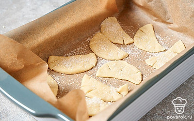 Сделайте на получившихся полукруглых печеньях по 2-3 надреза по краям. Еще раз посыпьте сахаром и переложите печенье на противень с пергаментной бумагой. Установите противень в середине горячей духовки и выпекайте печенье около 20 минут до яркого золотистого цвета.