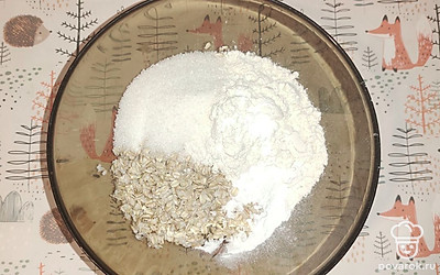 Смешайте в глубокой миске овсяные хлопья, сахар, муку, ванилин и разрыхлитель.