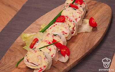 Подавайте рулетики на листах салата, украшенных помидорами черри.