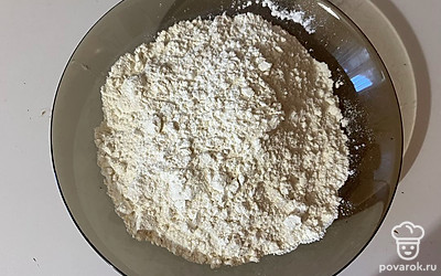 Муку просейте в отдельную тарелку и перемешайте ее с разрыхлителем. 