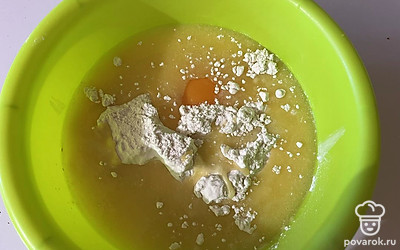 В глубокую емкость поместите растопленное сливочное масло, яйцо, сахар и муку с разрыхлителем. 