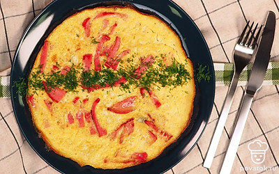 Готовый омлет сложите пополам, выложите на тарелку и украсьте мелко нарезанной свежей зеленью.