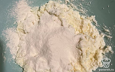 Постепенно просеять муку вместе с разрыхлителем в творожную массу. 