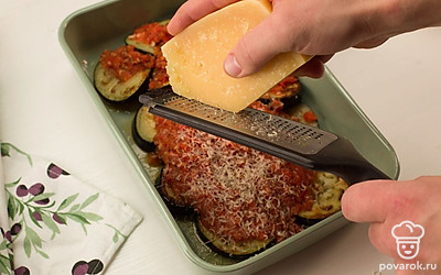 В форму для запекания вылейте получившуюся томатную пасту, выложите баклажаны и присыпьте сыром. Отправьте форму в разогретую духовку на 15 минут.