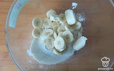 Банан порежьте на тонкие ломтики, добавьте сахар и масло.