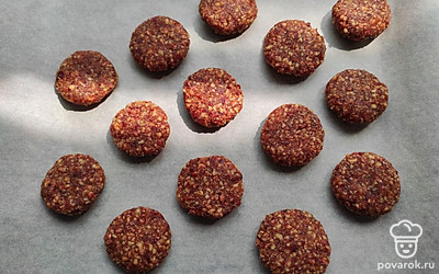 Соедините орехи и финики. Перемешивайте несколько минут, пока масса не станет однородной. Скатайте шарики размером с грецкий орех, приплюсните их и выложите на противень. Запекайте в духовке при 160 градусах 15 минут. 