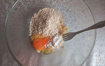 Банан разминаем вилкой в миске. Добавляем туда овсяные хлопья, яйцо и разрыхлитель теста.