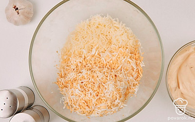 На мелкой терке натрите сыр и вареные яйца. Переложите ингредиенты в глубокую миску