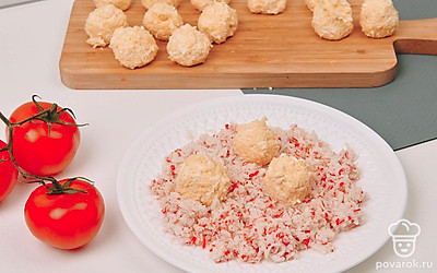 На мелкой терке натрите крабовые палочки. Каждый шарик обсыпьте крабовой массой.