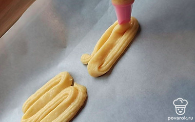 Пока духовка разогревается, выложим на противень тесто с помощью кондитерского мешочка.