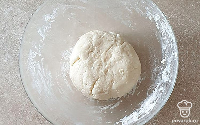 К смеси постепенно просейте муку, замешайте мягкое тесто сначала ложкой, а затем рукой. Сформируйте тесто в шар, положите в пакет и уберите в холодильник на 35-40 минут.