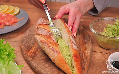Смажьте багет изнутри получившейся пастой из авокадо. Этот продукт, насыщенный полезными растительными жирами, заменяет в данном рецепте сливочное масло, а по вкусу оно идеально сочетается с семгой.
