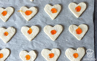 Джем выложите в кулинарный мешок или в обычный пакет и отрежьте уголок. В углубление в печенье выдавите небольшое колличество джема. Выпекайте в заранее разогретой до 180 градусов духовке около 17 минут.
