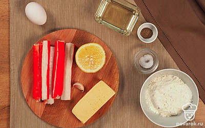 Подготовьте глубокую миску для приготовления кляра, бумажное полотенце, сковороду. Выложите все ингредиенты на видное место. Разморозьте крабовые палочки, чтобы они были мягкими. Измельчите чеснок.