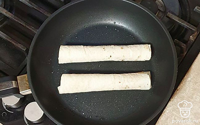 Затем лаваш сверните в трубочки и выложите на разогретую сковороду. Обжарьте со всех сторон на среднем огне.