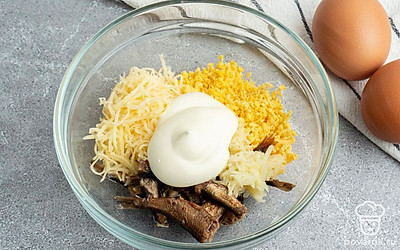 Измельчите чеснок и шпроты, натрите сыр. Добавьте к желткам шпроты, чеснок, сыр и майонез. Хорошо перемешайте.