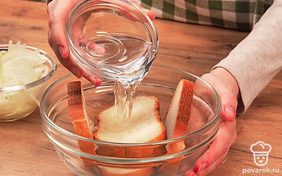 Подготовьте продукты. Проверьте, чтобы филе сельди было без косточек. Нарежьте рыбу на небольшие кусочки. Лук нарежьте полукольцами. Из лимона выдавите 1 ст.л. сока и сбрызните лук. Оставьте промариноваться на 5 минут. Очистите яблоко от кожуры и удалите сердцевину. Батон полейте водой и оставьте размокнуть.