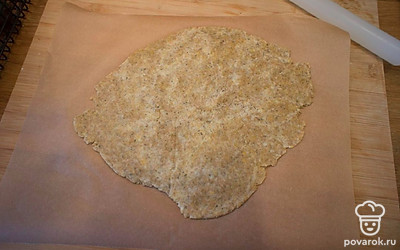 Поставьте духовку разогреваться до 180 градусов. Раскатайте тесто на пергаменте. Если оно будет липнуть к скалке, чтобы не добавлять муку, накройте его вторым листом и раскатайте между двумя листами пергамента до толщины 3-4 мм.