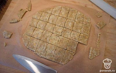 Ножом нарежьте тесто на квадратики и переложите их на противень, застеленный пергаментом, на небольшом расстоянии друг от друга. Если вы замечаете, что они получились толще, чем надо, просто приплюсните их пальцами.