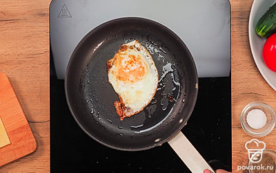 Поджарьте яйцо. Разогретую сковороду смажьте растительным маслом и разбейте в нее яйцо. Жарьте 2 минуты. Доведите желток до полуготового состояния.
