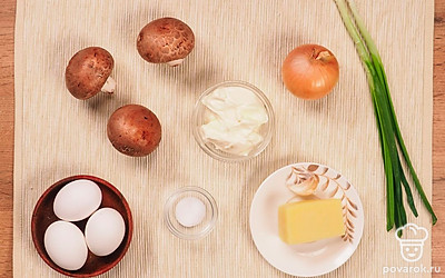 Отварите яйца вкрутую, остудите и очистите от скорлупы.Разрежьте яйца пополам. Мелко нарежьте шампиньоны и репчатый лук. Вымойте, проcушите и очистите шампиньоны. Очистите репчатый лук, зеленый лук вымойте и мелко порубите. Чеснок очистите и измельчите. Натрите на терке сыр.