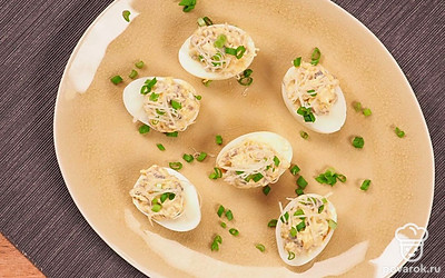 Яйца, фаршированные шампиньонами выложите на сервировочное блюдо, сверху украсьте мелко нарезанным зеленым луком.