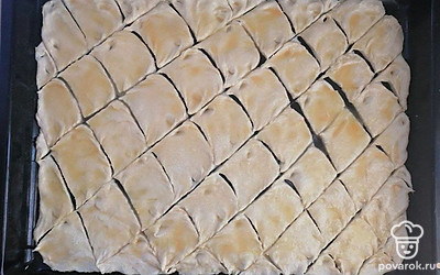 Ножом разделите лепешку на одинаковые фрагменты, создавая, таким образом, форму будущему печенью. Поместите противень в предварительно разогретую до 200ºC духовку. Выпекайте около 20 минут. Печенье должно немного подрумяниться.