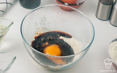 Приготовьте кляр для грибов: в миску разбейте яйцо, добавьте соль, молотый перец, сахар, муку и соевый соус. Всё перемешайте до однородной массы.