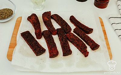 Выложите гренки на салфетки, дайте жиру стечь. Затем переверните, чтобы жир стек с другой стороны тоже.