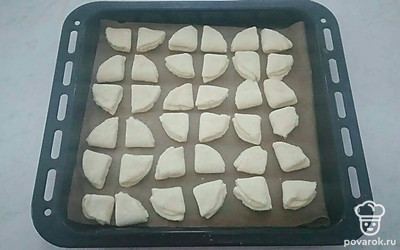 Полученные треугольники переложите на противень. Смажьте сверху взбитым желтком, посыпьте сахаром. Выпекайте в духовке, разогретой до 180 °C ориентировочно 20 минут.