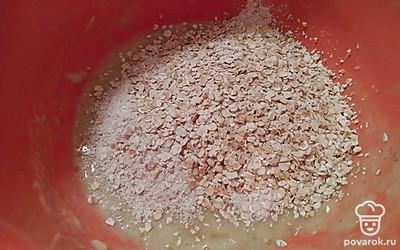 В банановое пюре всыпьте овсяные хлопья, часть хлопьев измельчите блендером и добавьте к бананам.