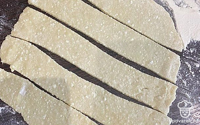 Раскатать каждый шарик на припыленной мукой доске и порезать на полоски.