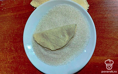 Сложить кружок пополам сахарной стороной вовнутрь и снова обмакнуть в сахар.