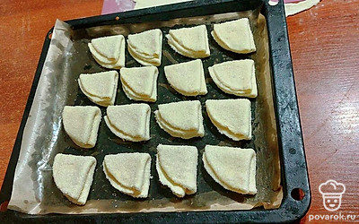 Выложить треугольнички на противень, смазанный маслом. Выпекать 25 минут при температуре духовки 180 градусов.