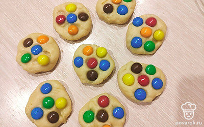 Сформируйте лепешки и прилепите по 4-5 конфеток на каждую. Выложите на пергамент и выпекайте при 180 градусах 15-20 минут.