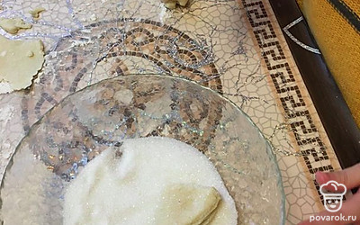 Обмакните кружочки в сахар, сложите в конвертики в четверть и разложите на противне.